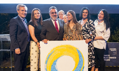 Grupo de personas en el escenario junto a un cuadro