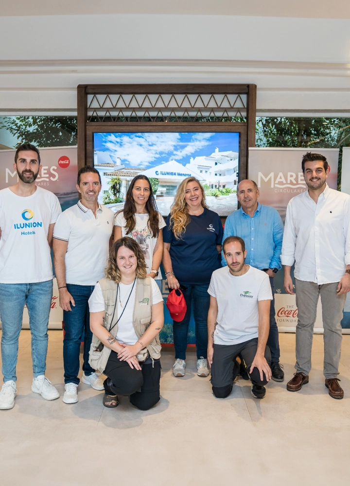 Equipo de ILUNION Hotels posando después de la intervención en la playa de Cala Galdana para promover la sostenibilidad