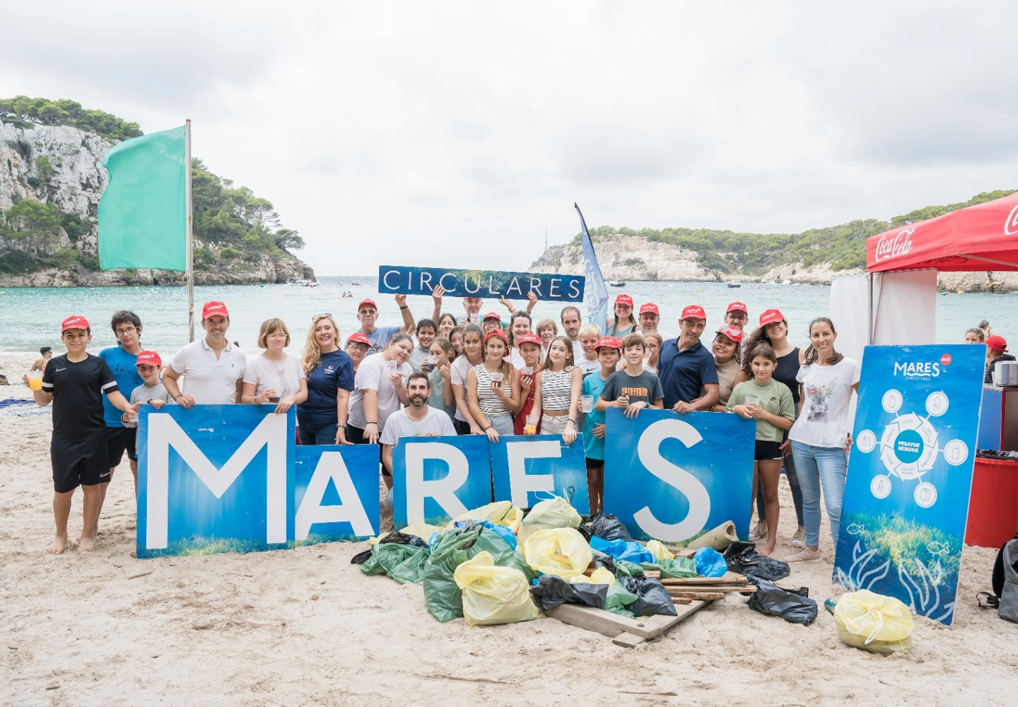 Voluntarios de ILUNION Hotels posando despues de recoger basura en la playa de Cala Galdana como parte de la iniciativa Mares Circulares.